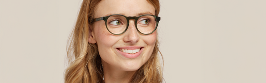 Portrait d’une femme blonde souriante avec monture verte élégante – Favoris lunettes du printemps