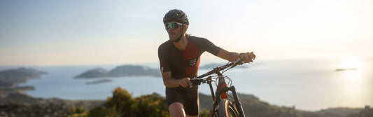 Homme faisant du vélo avec monture de sport Lunettes Pour Tous – verres de protection UV et branches antidérapantes
